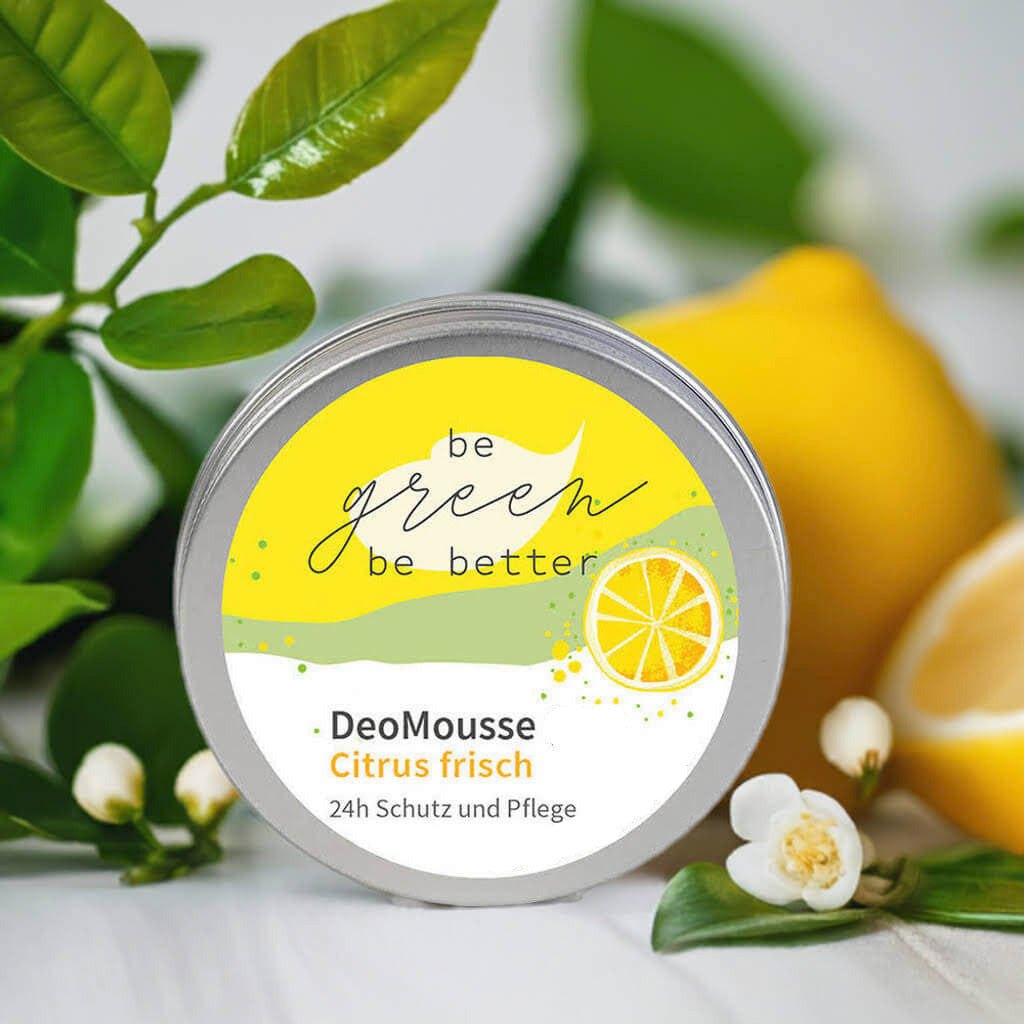 Naturkosmetik DeoMousse "Citrus frisch" in Blechdose neben Zitronen und Blüten