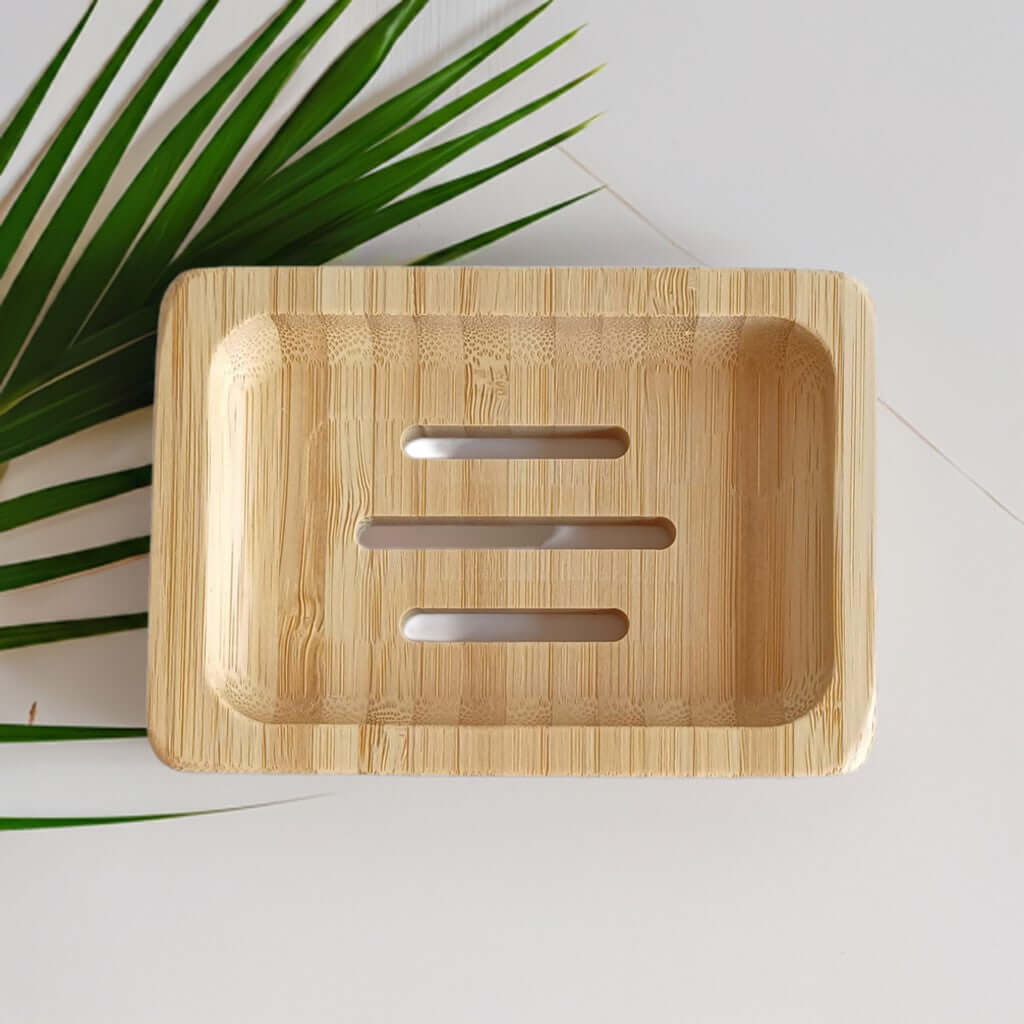 Bambusablage in rechteckiger Form neben Palmenzweig