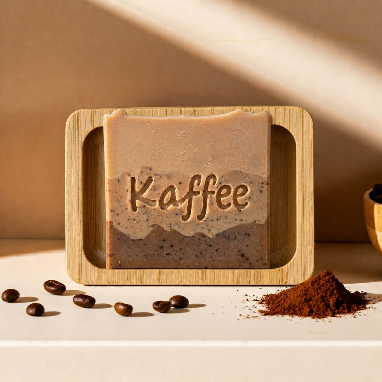 Bio Seife 'Kaffee' in handgefertigtem Design auf Bambusholzablage mit Kaffeebohnen 